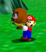 Mario holding a Goomba clone in the game Super Mario 64.