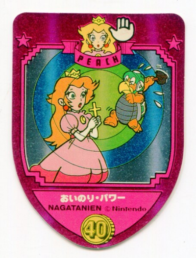 A pink shield-shaped sticker features a small image on the "shield" which has a blue background. Upon this blue background are Princess Peach, to the left, with a vaguely shocked or startled expression on her face, and with both hands grasping the base of a cross. Peach is holding the cross in front of her a bit above chest level. On the right, a Hammer Bro., apparently in the middle of jumping up, appears to be struggling to hit Peach with its hammer. Its hammer is held above and behind its head, as if it has been stopped mid-swing, with four beads of sweat coming off the Hammer Bro. indicating its exertion. From the cross in Peach's hand, three large circles radiate outwards, the central circle being colored lime-green, the next circle out encompassing the first and being a darker green, and the final circle encompassing the second and being colored a light blue.