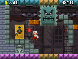 Mario Jumping to reach a door and avoid a Big Thwomp in the level World 8-Bowser Castle.