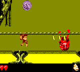 Dixie Kong climbing toward a Klasp from a rope above a pool of molten lava in Barrel Boulevard from Donkey Kong GB: Dinky Kong & Dixie Kong