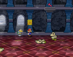 Mario next to the Shine Sprite in the stair switch room in Hooktail Castle in Paper Mario: The Thousand-Year Door.