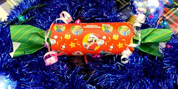 Photograph of a party cracker wrapped in holiday Mario-themed material