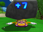 After Wario finishes with a double bogey or worse, he hurls a big boulder into the air, only for it to come back and crush Wario, turning him flat.