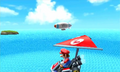 Mario gliding through the air and the Wii blimp in the background in Wuhu Island.