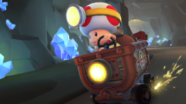 Captain Toad driving the Clanky Kart on N64 Choco Mountain in Mario Kart Tour