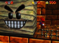 An early screenshot of Mario inside the Shifting Sand Land pyramid, featuring a Grindel with a slightly different smile, whiter teeth, black eyes, and bushier eyebrows
