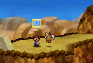 Mario standing next to the Super Block in Mt. Rugged in Paper Mario.