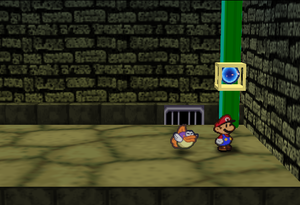 Mario standing next to the Super Block in Toad Town in Paper Mario.