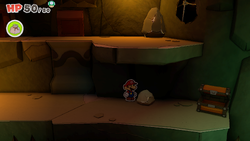 Mario standing near a rock containing a Small Bag of Confetti in Earth Vellumental Temple of The Origami King.