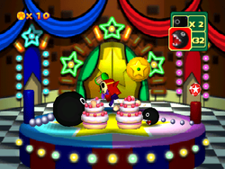 Game Guy's Sweet Surprise: Two differently sized Chain Chomps devouring their own cakes. From Mario Party 3.
