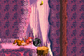 The Kongs moving a tire onto a platform leading up to a hidden area with the letter N in the Game Boy Advance version