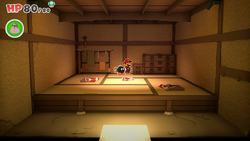 Mario standing near a cupboard containing a Coin in Shogun Studios of The Origami King.
