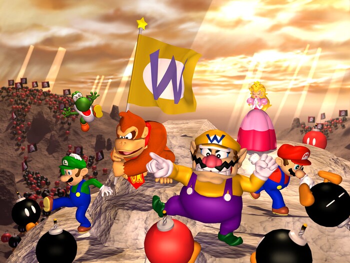 Mario, Luigi, Wario, Donkey Kong, Peach, and Yoshi stand atop a rock in Wario's Battle Canyon, using N64 era renders. They appear to be fighting against a large number of Bob-ombs. In the background, there are many Bob-ombs and Bob-omb Buddies, apparently fighting, with some hoisting banners that are half-red and half-black with a white Bob-omb symbol on top of them. Yoshi is leaping up into the air with a shocked expression and his hands splayed out. Luigi, with a leg extended, is looking at a Bob-omb with concern. Donkey Kong holds a flag with Wario's purple "W" over a white circle surrounded by yellow. Wario points while looking at a Bob-omb Buddy. Mario punches a Bob-omb away, and, behind them all, Peach stands with her eyes closed and her hands folded in prayer.