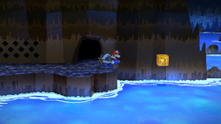 Mario next to the Shine Sprite above water in the Pirate's Grotto in the remake of the Paper Mario: The Thousand-Year Door for the Nintendo Switch.