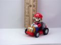 A figurine of Mario from from Super Mario Kart driving his kart