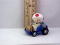 A figurine of Toad from from Super Mario Kart driving his kart