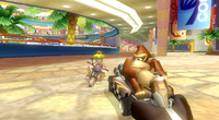 Donkey Kong and Princess Peach are racing in Coconut Mall in Mario Kart Wii.