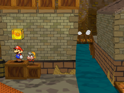 Mario next to the Shine Sprite in the back-east corner of the east Rogueport room in Paper Mario: The Thousand-Year Door.
