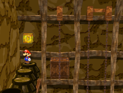 Mario next to the Shine Sprite in the storeroom with a ! switch in Pirate's Grotto in Paper Mario: The Thousand-Year Door.