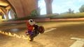 A red Shy Guy, performing a wheelie on its Flame Rider, in Mario Kart 8