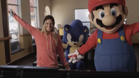 Jamie Anderson playing Mario & Sonic at the Sochi 2014 Olympic Winter Games with Mario as Sonic watches.
