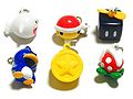 Light-up figurine keychains with items based on New Super Mario Bros. Wii. The Boo, River Piranha Plant, and Red Shell light up red; while the Penguin Suit, Propeller Block, and Star Coin light up yellow