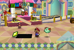 Mario finding a Star Piece in front of the pink station in Shy Guy's Toy Box in Paper Mario