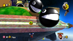 Mario hides from two massive rolling Chomps in Super Mario Galaxy.