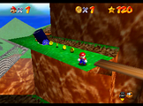 Mario stands on the mountain's cannon ledge.