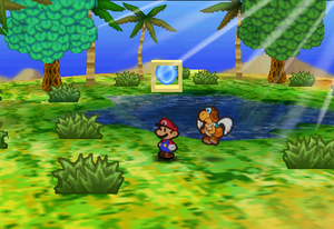 Mario standing next to the Super Block in the oasis of Dry Dry Desert in Paper Mario.