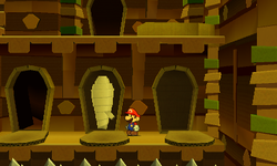 Mario near an opened coffin containing a POW Block Sticker in Sandshifter Ruins of Paper Mario: Sticker Star.