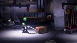 Luigi using a Suction Shot on a briefcase in Luigi's Mansion 3.
