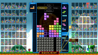 The Super Mario All-Stars theme in Tetris 99, showing Small Mario standing in a flat grassy overworld of the type used for Super Mario Bros. and Super Mario Bros.: The Lost Levels within All-Stars, a few blocks and a Warp Pipe on the right, a Mini Luigi on top, as well as the general gameplay view.