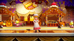 Patissiere Peach slightly to the right of the center door of the cake decoration bakery while idling in Princess Peach: Showtime!.
