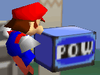Mario next to a POW Block in Super Smash Bros.