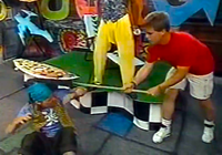 Joseph Bridgers (right) hitting Tommy Treehugger (left) with his shark fin pole in the Club Mario segment for The Super Mario Bros. Super Show! episode "Pirates of Koopa"