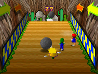 Boulder Balls: Three players trying to reach for the top in order to win the mini-game, with Wario already hit by a rolling boulder. From Mario Party 3.