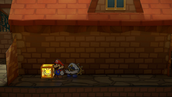 Mario next to the Shine Sprite after the wall to the left of the store in west Rogueport in the remake of the Paper Mario: The Thousand-Year Door for the Nintendo Switch.