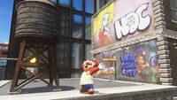 Super Mario Odyssey screenshot of Metro Kingdom. The graffiti originates from Donkey Kong's arcade bezelMedia:DK Artwork Cabinet bezel.png illustrated by Shigeru Miyamoto.