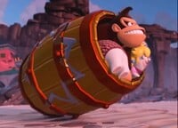 Donkey Kong, Rabbid Peach and Rabbid Cranky about to launch themselves out of a Golden Blast Barrel to defeat Mega Rabbid Kong in the Donkey Kong Adventure DLC for Mario + Rabbids Kingdom Battle