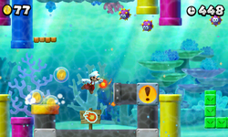 Fire Mario, at an underwater level, throwing fireballs into a pipe that coins pop out of.