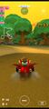 Mario (Swimwear) driving on muddy terrain in the Mario Kart Tour rendition of GBA Riverside Park