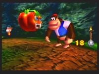 Chunky Kong battling a Tomato in Fungi Forest while in his Hunky Chunky form in Donkey Kong 64
