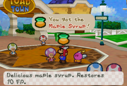 Mario receiveing a Maple Syrup from Trading Event Toad in Toad Town of Paper Mario.