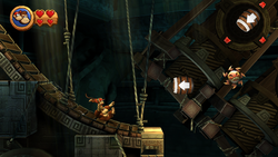 The Kongs slide down a ramp in Button Bash, a level of Donkey Kong Country Returns.