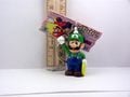Luigi holding a single Coin keychain from the first Mario Party game