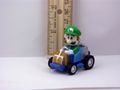 A figurine of Luigi from from Super Mario Kart driving his kart