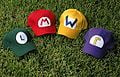 A collection of hats that represent (from left to right) Luigi, Mario, Wario, and Waluigi
