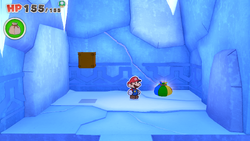 Mario standing near a Big Bag of Confetti on Ice Vellumental Mountain of The Origami King.