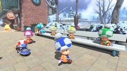 Various Toads in winter clothing by the train station in Mario Kart World, more specifically the one that leads to Starview Peak